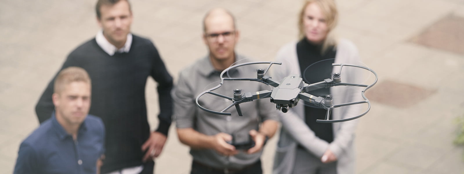 drone med fire personer i baggrunden