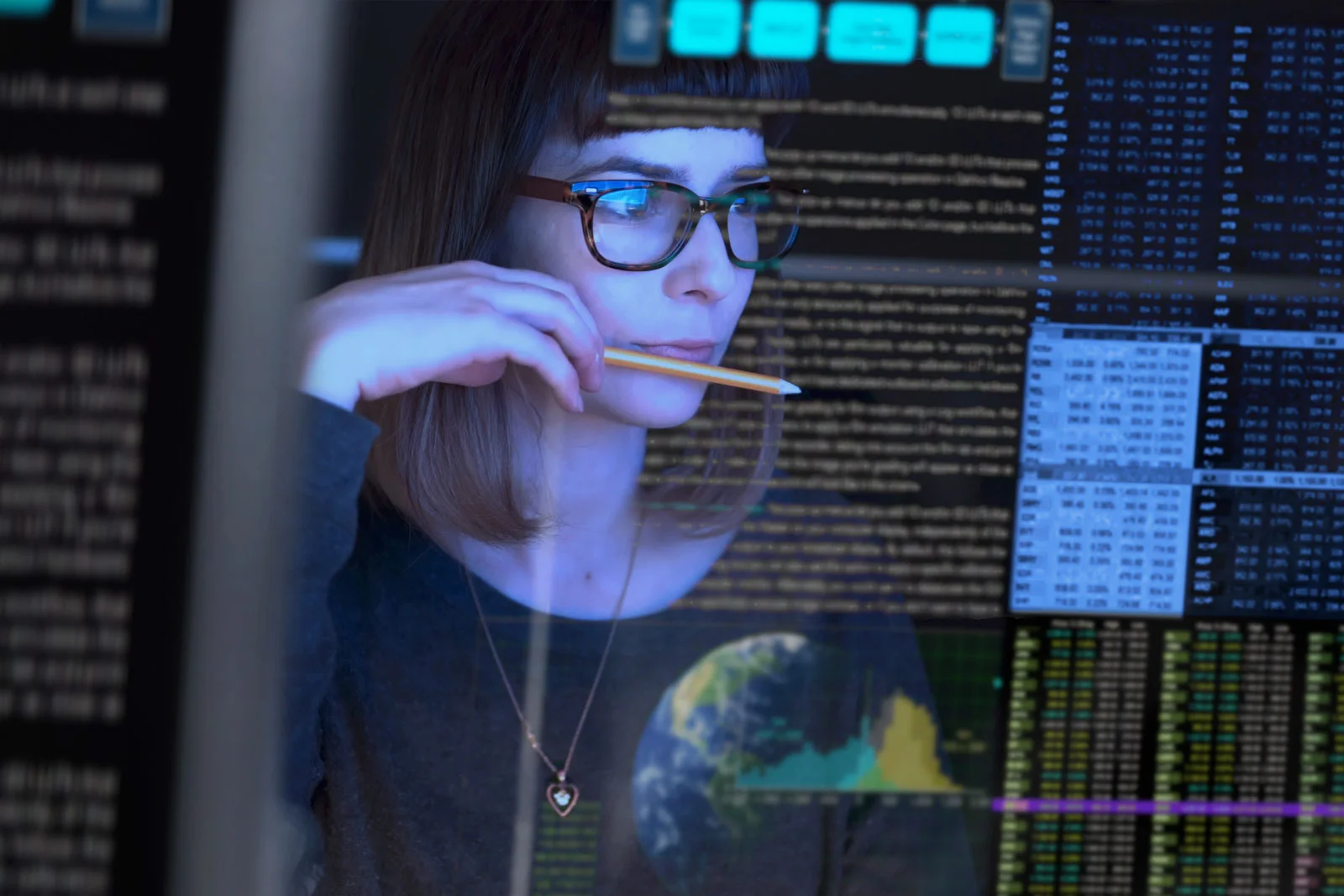 billede af en ung kvinde, der studerer en gennemsigtig computerskærm og overvejer.
