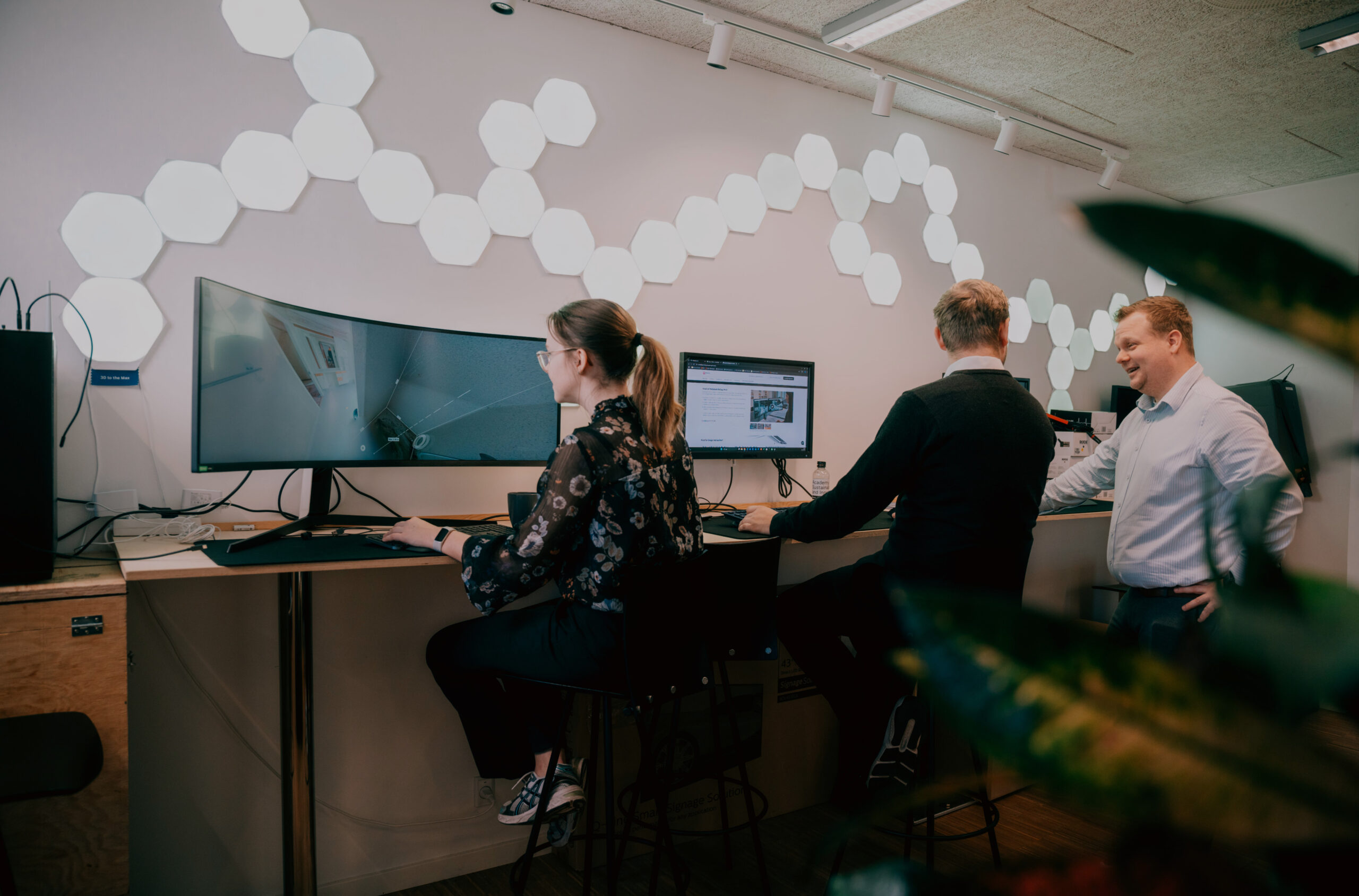 To studerende sidder på kontor og arbejder ved deres computere.